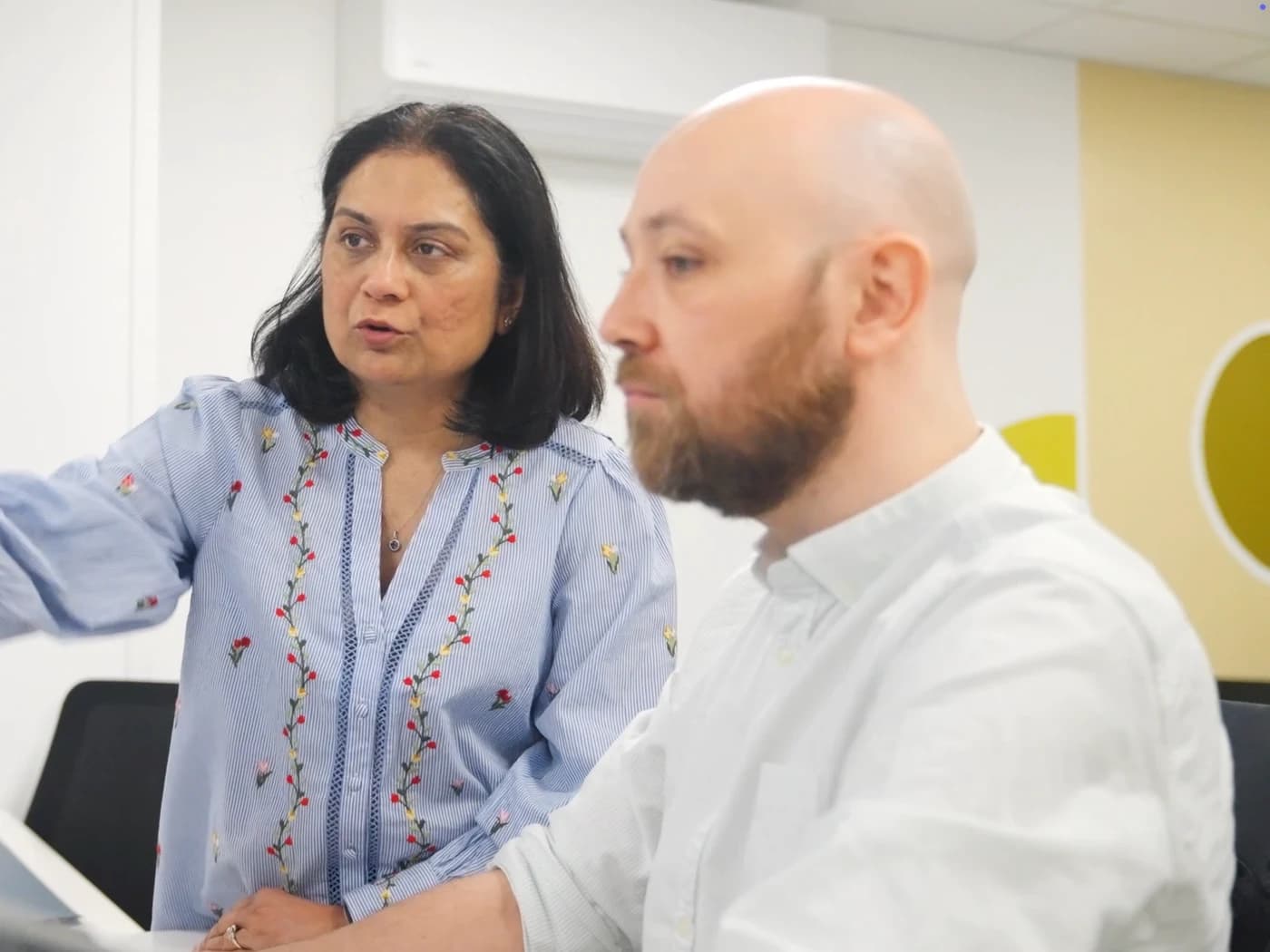 Two World Products team members reviewing work on screen together