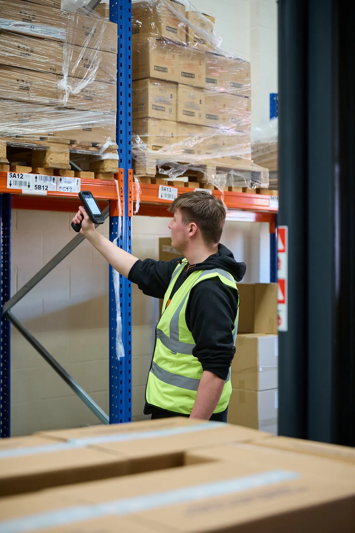 A World Products operative scanning stock against its rack location in the fulfilment warehouse